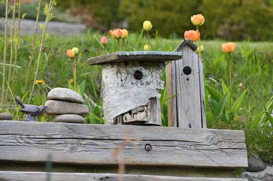 Old wooden birdhouses on the corner of an old bench.