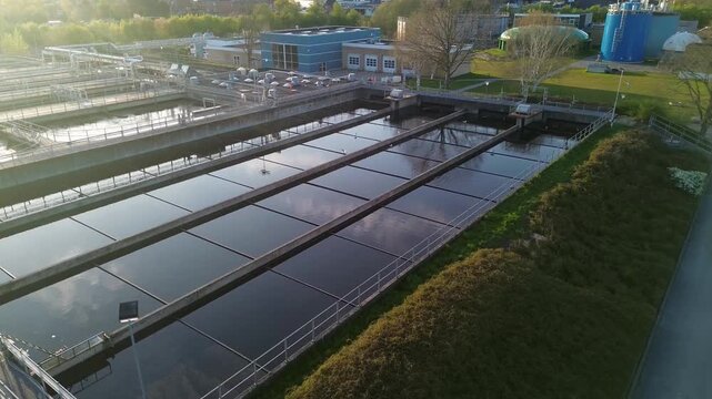 Active wastewater treatment facility with various rectangular purification tanks and industrial structures. The video highlights the scale and technical complexity of modern environmental protection