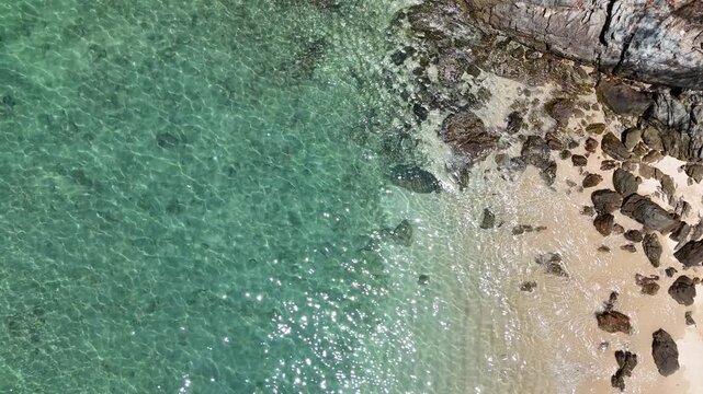 Aerial View of Rocky Coastline with Turquoise Water and Sandy Beach Creating Serene and Inviting Atmosphere