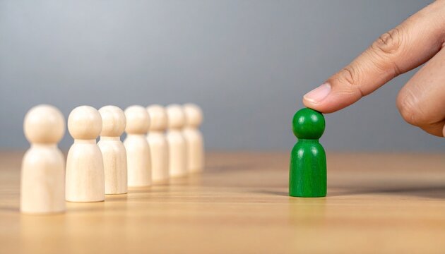 Hand pushing green figurine away from group, symbolizing exclusion or individuality.