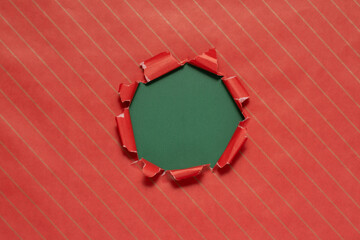Torn red wrapping paper revealing a green background © Ms VectorPlus