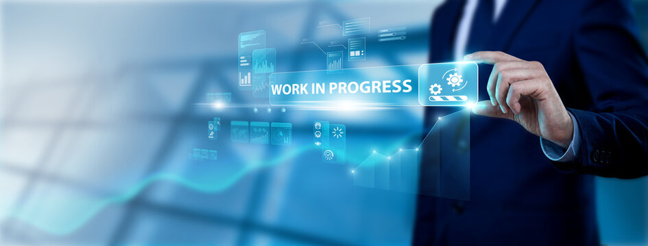 Production Lead Hand Holding Work In Progress Interface on Digital Screen, tracking current builds. Monitoring active development stages to ensure timely completion of industrial projects.