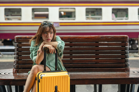 Young woman depressed mistakes a train. Female backpacker Traveler waiting at train station. Boarding the wrong ticket feeling stressed. Planning Fail trip tourist missing
