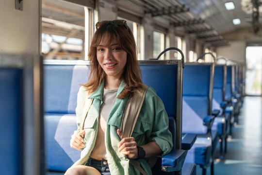 Freedom traveler beautiful woman at terminal train station. Happy tourist travel by train on vacation time holiday weekend trip. Female Backpacker arrival at platform railway.