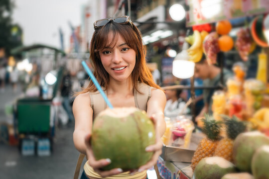 Young woman enjoy eating street food at night market. Traveler blogger women Happy tourists Beautiful female with Traditional food local road at thailand bangkok city.