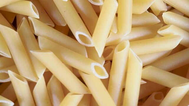 Raw penne pasta rotating food background