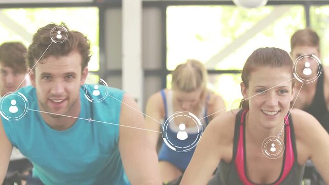 Two front riders leaning on bikes pedaling in fitness class, camera pulling back linking user icons