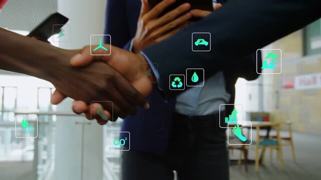 Man starting clasp, woman joining, tablet rep tapping, green icons over hands sealing energy deal