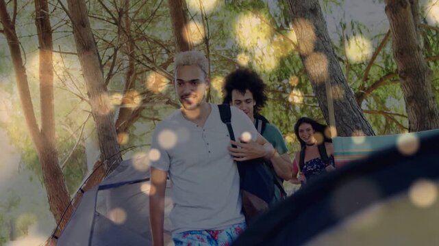 3 campers walking out from shaded campsite toward camera, bokeh highlighting backpacks for travel