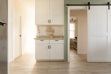 Contemporary home interior with white cabinetry and barn door © Djavan Rodriguez