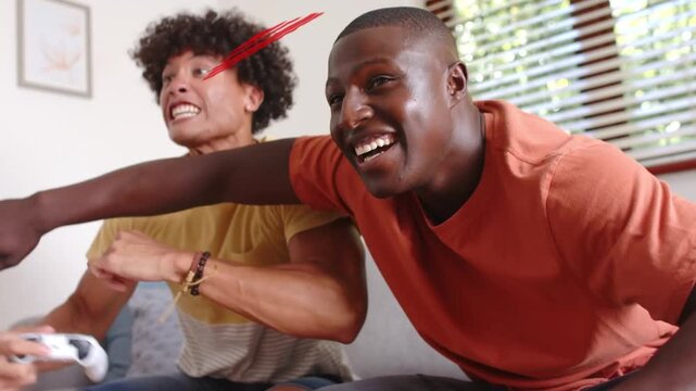 Two male players reacting to game-cue, laughing and reaching with pads, red speech icon over faces