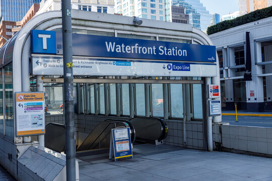The blue Waterfront Station SkyTrain entrance sign and arched canopy with directions to the Canada Line and Expo Line in downtown Vancouver.