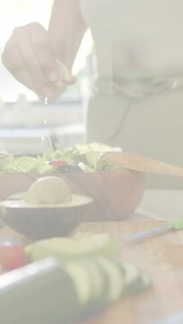 Vertical video: Home cook pinching salt, sprinkling over salad, animated droplets highlighting food