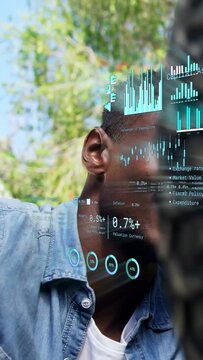 Vertical video: Man reaching past bike spokes into tech overlay, moving graphs, checking ride data