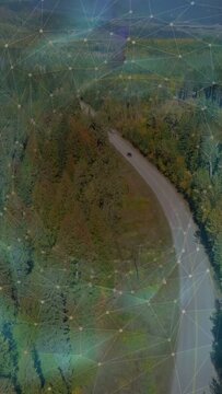 Vertical video: Drone shifting, revealing SUV moving curved road past forest, overlay showing route