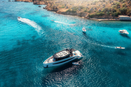Aerial drone view of beautiful luxury yachts and boats in blue sea in summer. Sardinia island, Italy. Top down view of speed boats, turquoise water. Tropical landscape. Yachting. Seascape. Summer vibe
