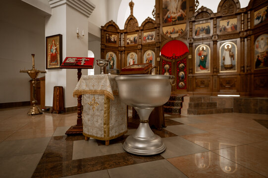 Orthodox baptismal font and iconostasis in church interior for christian christening ceremony