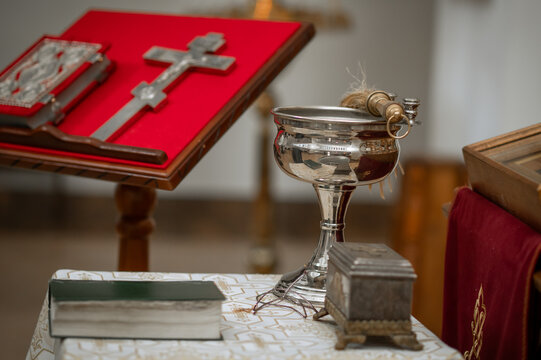Orthodox Gospel book and silver cross on red velvet lectern in church with iconostasis background