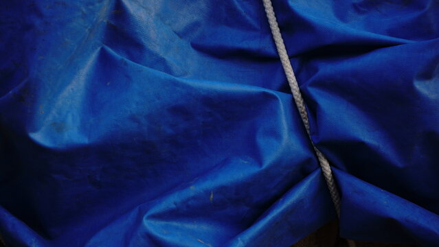 blue tarpaulin waving and white rope as a background