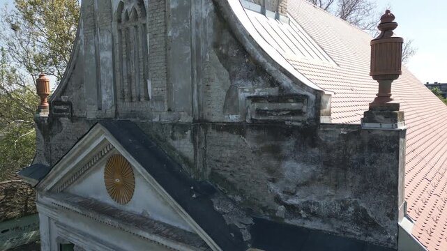 Aerial close-up ascending shot of the weathered facade of the Reformed Christian Church in Vrbas, Serbia.
