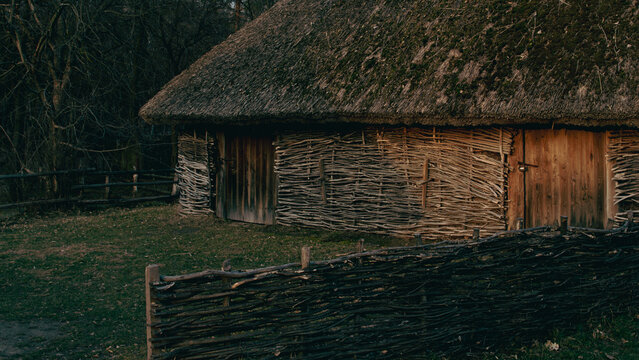 Traditional Ukrainian wicker outbuilding under a heavy straw and moss roof