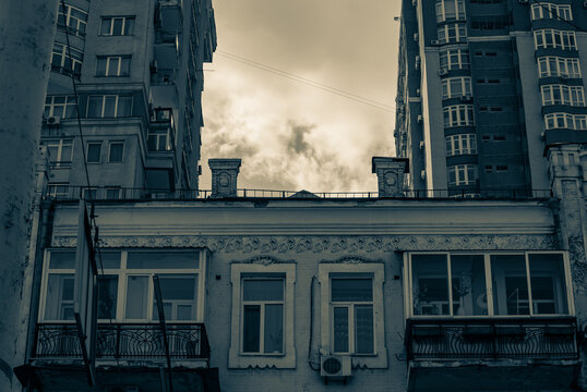 Dramatic cloudy sky framed by contrasting generations of city housing 