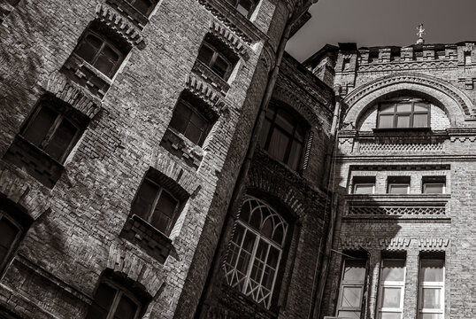 Dramatic monochrome facade with decorative corbelled arch and patterned cornice