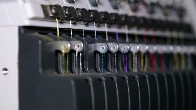The tension control unit of the thread of an industrial embroidery machine for embroidery on various fabrics, close-up. Background and foreground blanked out blurry. 4k video.
