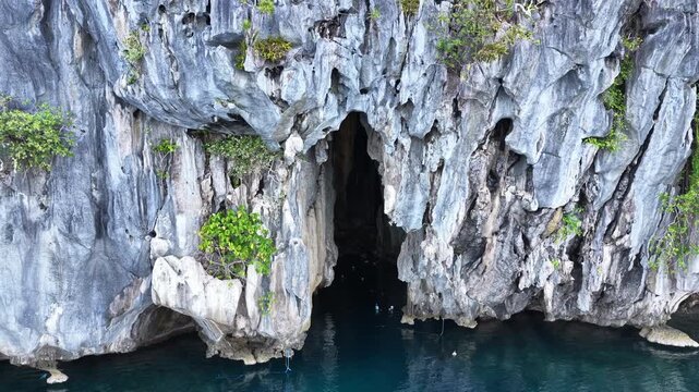 A small bangka drifts at the mouth of Cathedral Cave found in Pinisil Island, Philippines. This beautiful geologic marvel is a famous tourist attraction near El Nido, Palawan.