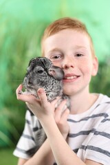 Obraz premium Child with his cute chinchilla on blurred background