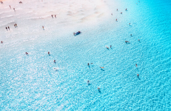Aerial drone view of clear blue sea with swimming people. Top view of sandy beach with white sand,turquoise water on sunny day. Summer in La Pelosa beach, Sardinia, Italy. Tropical. Summer vacation