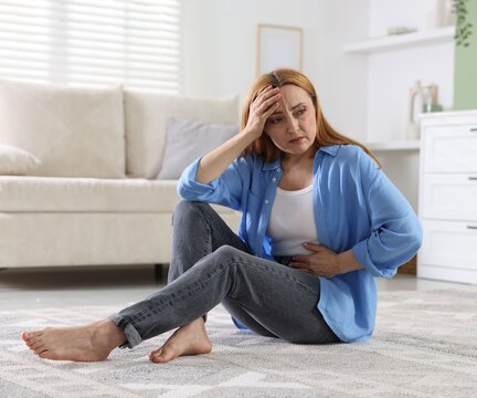 Menopause. Woman suffering from abdominal pain at home