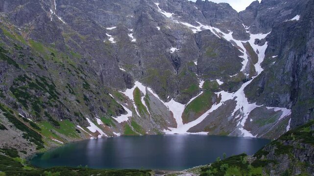 Stunning aerial view of Morskie Oko lake nestled in the Tatra Mountains, near Zakopane. Surrounded by lush greenery and rugged cliffs, the serene water creates a breathtaking natural landscape