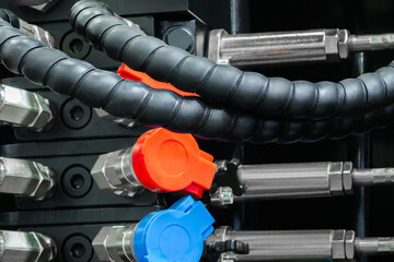 Obraz premium Part of a hydraulic industrial machine, control levers of a hydraulic machine, industrial High pressure hydraulic hose system connected to steel pipes, close-up. Marine hydraulics. conceptconcept