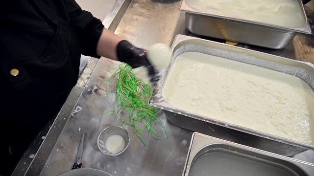 Preparing burrata cheese with stracciatella in a commercial kitchen setting