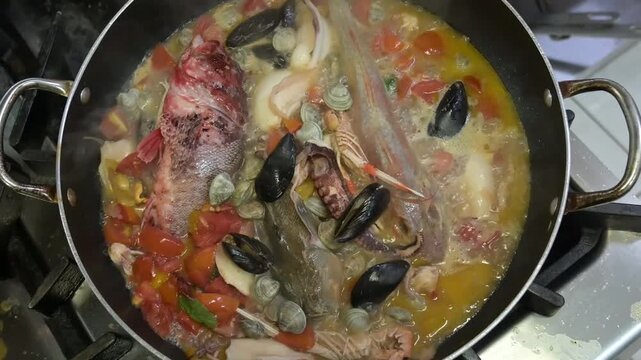preparazione di una zuppa di pesce nella cucina di un ristorante