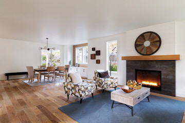 Fototapeta premium A modern living room with a fireplace and an open dining area in a bright contemporary home. Natural light