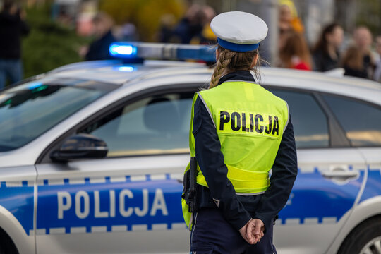 Policjantka kontroluje ruch drogowy pojazd&oacute;w na drodze. 