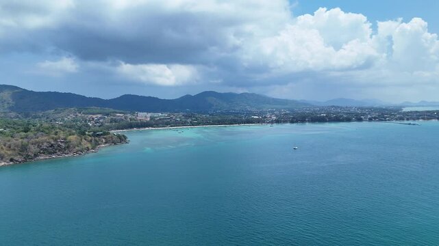 Aerial View of Serene Coastal Landscape with Turquoise Waters and Lush Hills Under Partly Cloudy Sky Evoking Peace and Natural Tranquility