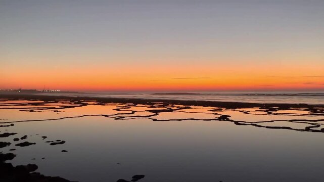 Golden Sunset Beach in Tangier Morocco with Calm Ocean Waves and Mirror Reflections