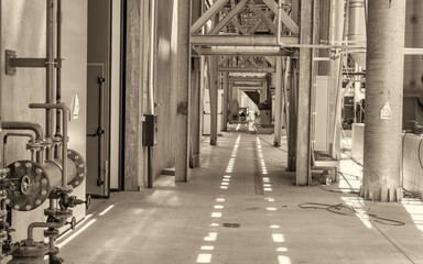 Naklejka premium Large unfinished industrial space featuring metal beam framework and raw warehouse construction interior details