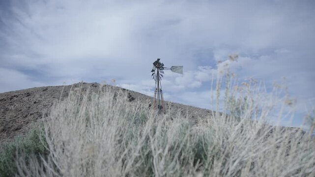 Broken Windmill Standing in Desert Winds Along Remote Highway - Cinematic Desert Relic - Timeworn, Abandoned. 4k 30fps