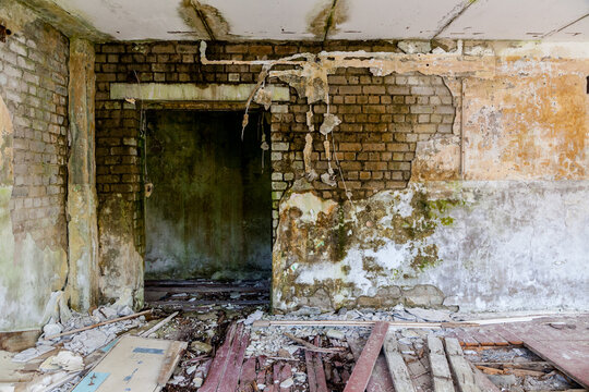 An abandoned Soviet military base in Saarema, Estonia, with peeling walls, broken floorboards, rubble and scattered debris across a decaying room