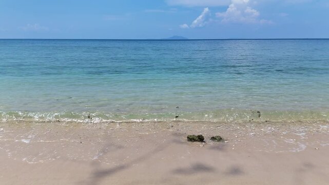 Serene Beach Scene with Gentle Waves Lapping at Sandy Shore Under Clear Blue Sky and Bright Horizon on Tranquil Island Oceanfront