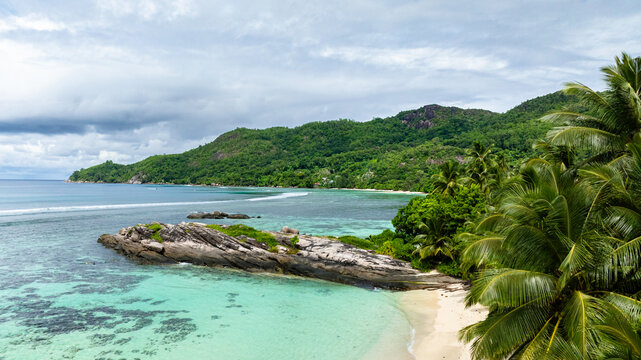 Rocky outcrop surrounded by turquoise waters and beach. Anse Forbans. Seychelles, Mahe.