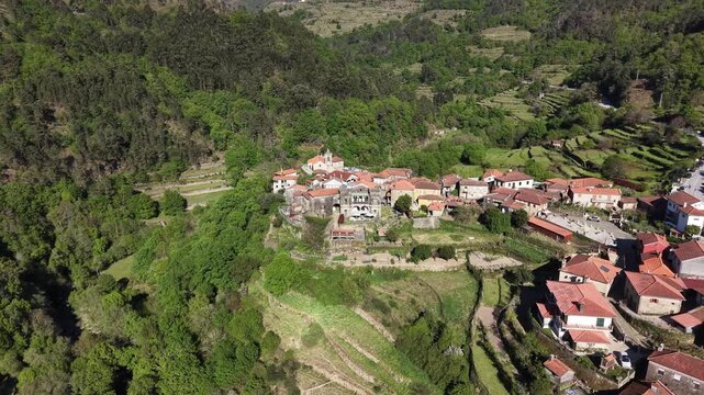 Sistelo village nestled in mountains with traditional stone houses and green terraced fields