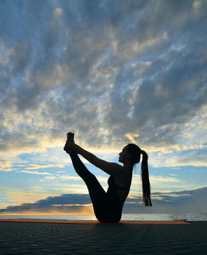 urdhva navasana upward boat pose Woman girl lady silhouette of stretching outdoors, fit female doing asana pose at sunset, yoga exercise in nature, side view full length Evening sunset sky background
