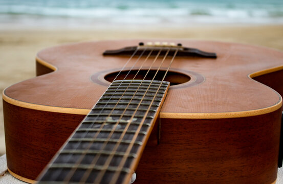 Acoustic Guitar on Beach Sand with Ocean Background