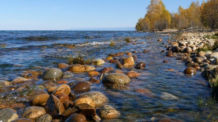 The rocky coast of Lake Baikal, dotted with unusual round, multi-colored boulders with beautiful carved patterns.  © panserg