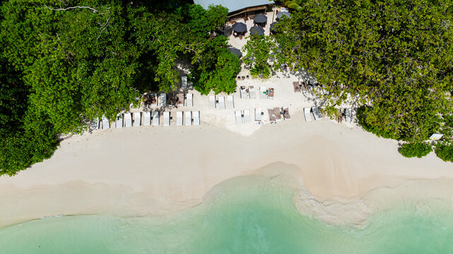 Tropical beach with clear turquoise water, white sand, and lush green trees. Seychelles, Mahe. Launay Beach.